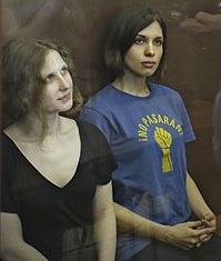 Feminist punk group Pussy Riot members Maria Alekhina and Nadezhda Tolokonnikova sit in a glass cage in a Moscow courtroom